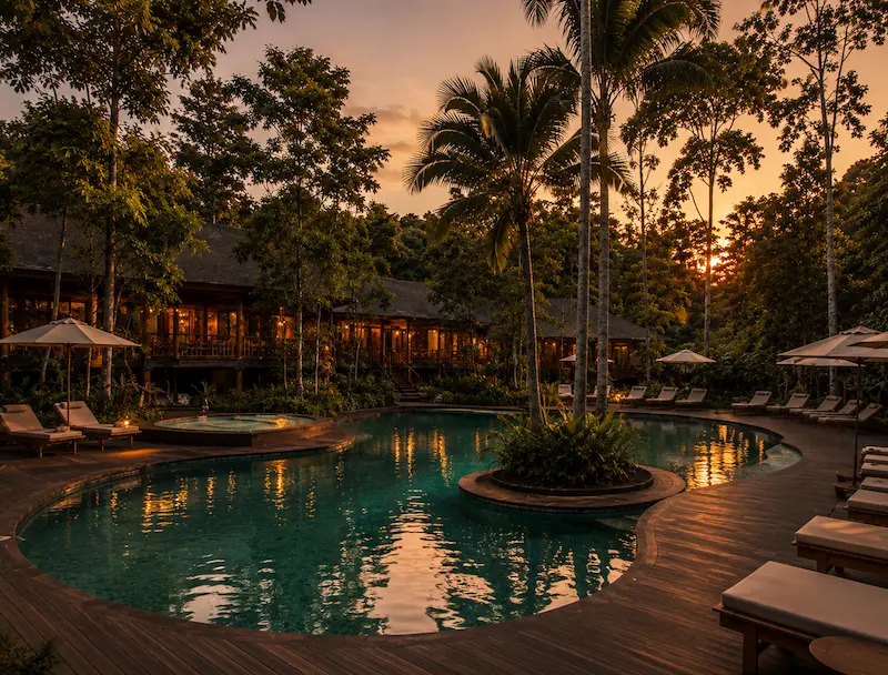 Piscina al atardecer en entorno selvático - Hotel Yaguas