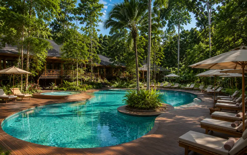 Piscina exterior del Hotel Yaguas con deck de madera y selva